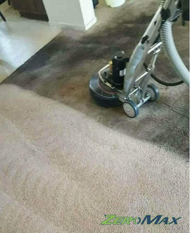 Professional carpet cleaning machine in action on stained carpet area