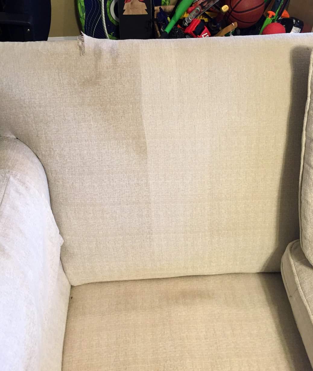 Cream-colored upholstered armchair with storage visible in background